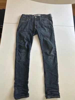 Levi’s Jeans - Snygga mörkblå jeans med smal passform och klassisk femficksdesign. Jeansen har normal midja, dragkedja och knapp framtill samt detaljerade sömmar på bakfickorna. Perfekta för en avslappnad och trendig stil. Modellen är 520 Extreme Taper Fit. Hör av dig om du har några frågor!