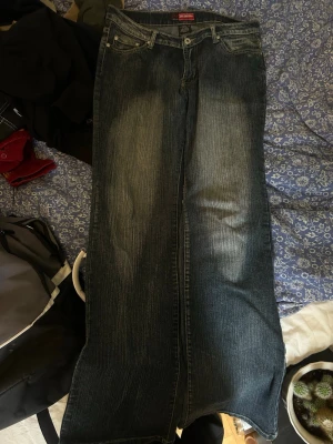 vintage jeans  - Säljer ett par blå bootcut jeans från p&p med slitningar 