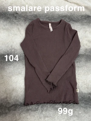 Brun ribbad långärmad tröja - Smalare passformad brun ribbad tröja med långa ärmar och vågig kant vid ärmslut och nederkant. Perfekt för dig som gillar en enkel men ändå snygg stil. 🌸 Fint använt skick. Storlek 104