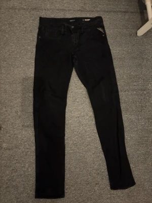 Svarta skinny jeans - Säljer ett par svarta skinny jeans med klassisk femficksdesign och dragkedja fram. Jeansen har smal passform och raka ben, perfekta till en avslappnad stil. Materialet ser ut att vara stretchigt för extra komfort.