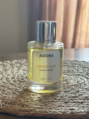 ADORA Lemon Kiss 50ml - ADORA Lemon Kiss 50ml! En superfrisk citrondoft med sötma, lite av en gourmand fast inte det där sötsliskiga, testsprutad en gång! Stått mörkt o svalt! 
