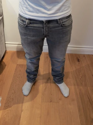 Jack & Jones  - Säljer ett par ljusblå jeans med klassisk femficksdesign och raka ben. Jeansen har en något tvättad look och normal midja. Materialet är denim och passformen är avslappnad men ändå snygg. Perfekta för en chill och stilren vardagsoutfit. Obs de t finns en väldigt otydlig fläck som man säkert enkelt kan få bort men nu är jeansen rena