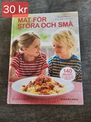 Mat för stora och små kokbok - Kokbok med titeln 'Mat för stora och små' av Charlotta Malhotra och Jessica Suel von Holstein. Omslaget visar två barn vid ett bord med en stor tallrik pasta. Boken innehåller 140 recept för hela familjen. Utgiven av Bonnier Fakta.