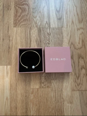 Guldigt armband från Edblad - Superfint armband från Edblad som tyvärr inte kommer till användning. Armbandet är aldrig använt så det är i nyskick. Låda medföljer.