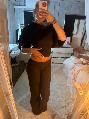 Brunt set med vida byxor - Säljer ett brunt set med croppad topp och vida byxor. Toppen har korta, vida ärmar och byxorna har låg midja och utsvängda ben. Byxorna är i storlek xxs och tröjan i xs. Jag är 167 cm lång och har storlek s vanligtvis. 