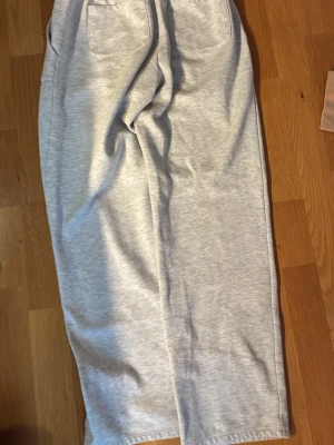 Ljusgrå mjukisbyxor från 157 - Ljusgrå mjukisbyxor från 157 med resår i midjan och två fickor fram. Tillverkade i mjukt och skönt material som passar perfekt för chill dagar. Raka ben och enkel design som är lätt att matcha med hoodies eller t-shirts.