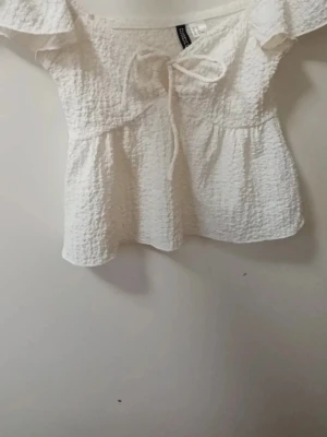 Supersöt sommartopp - Supersöt vit offshoulder blus med knyt framtill och volangärmar. Säljer för att den inte passar mig☺️ Skriv om du har någon fråga 🤗