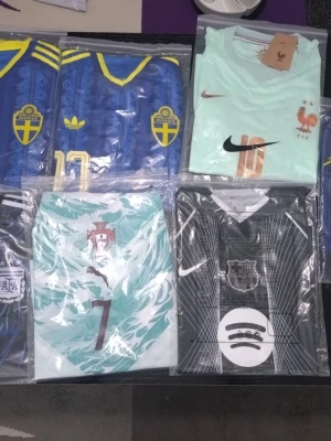 Blå Sverige fotbollströja Adidas - Säljer en blå Sverige fotbollströja från Adidas med gula detaljer och klassiskt landslagsemblem på bröstet. Tröjan har gul V-ringad krage, gula ränder på axlarna och ett retroinspirerat mönster. Perfekt för match eller träning!