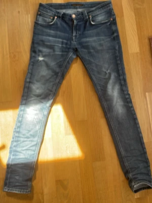 Nudie - Tja! Säljer ett par blå slim fit jeans från Nudie🍾Jeansen har en klassisk femficksdesign och smal passform med en jävligt fet tvätt. Perfekta för en trendig och avslappnad stil.