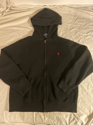 Svart zip hoodie från Polo Ralph Lauren - Klassisk svart hoodie med dragkedja från Polo Ralph Lauren. Har inga slitage märken på sig och sitter bra för storleken. 
