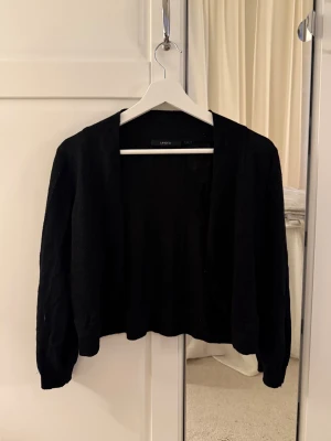 Svart bolero - Svart stickad bolero med ett fint subtilt shimmer och stickat mönster över hela. Perfekt cover up över en topp eller klänning🤩 Storlek m men passar xs/s också. Skriv vid frågor, köp gärna direkt💖