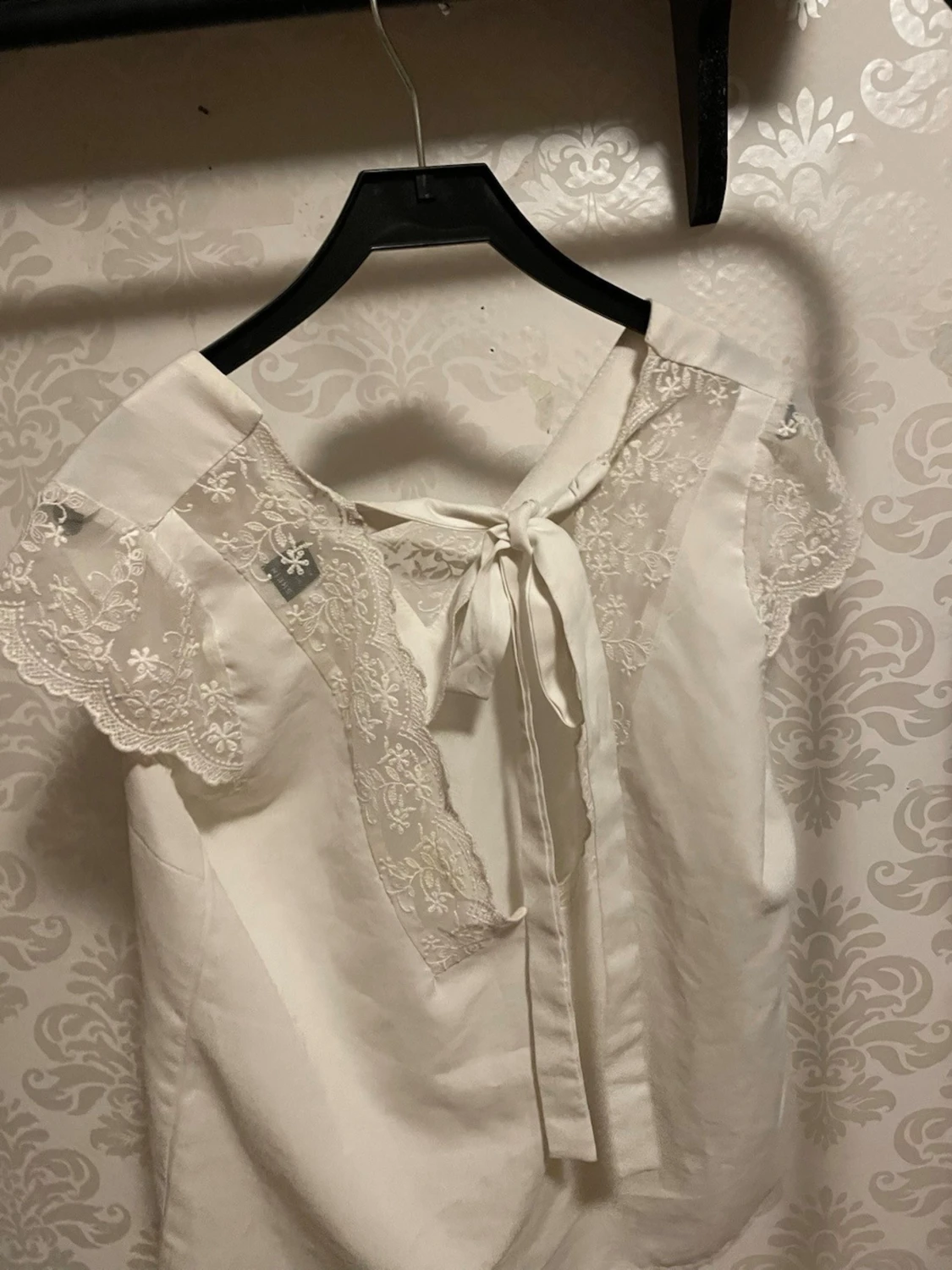 Vit blus med spetsdetaljer och rosett - 1