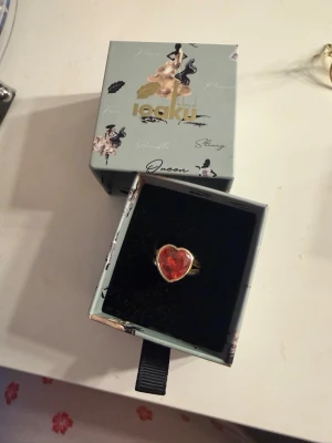 Ioaku ring hjärta  - Tecken på användning, (se bilder). Fortfarande mycket kvar att ge. Finns inte att köpa längre. Säljes då jag har bytt till silver. Ringen går att justera. Ingår box. 