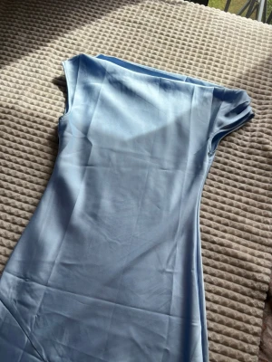 Ljusblå satin klänning - Snygg lång satin blå klänning som är of shoulder, lite tajtare överdel jämfört med underdel, som jag skulle säga är mer utsvängd. Bara använd en gång till balen 💞