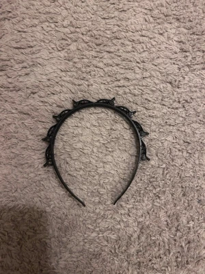 Svart plastdiadem med klämmor - Snyggt svart diadem i plast med dekorativa klämmor längs ovansidan. Diademet har en klassisk form och passar perfekt för att ge din look en söt och lekfull touch. Lätt och bekvämt att bära hela dagen.
