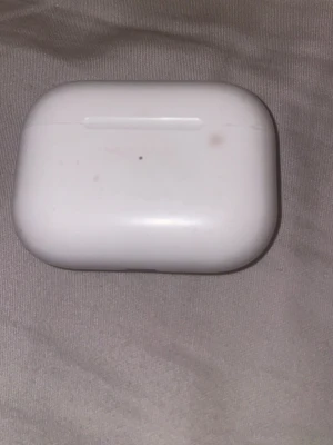 AirPod pro 2 - Säljer ett par vita trådlösa in-ear hörlurar med laddningsetui. Etuiet är kompakt och har en rundad form, perfekt att ha i fickan eller väskan. Passar till de flesta smartphones och ger smidig laddning på språng.