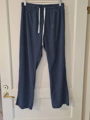 Blå prickiga pyjamasbyxor från Calvin Klein strl M dam - Mysiga pyjamasbyxor från Calvin Klein i mörkblått med vita prickar. Det finns ett märke i mage områden,  se sista bild. Etikett om material saknas. Storlek M.