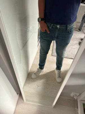 Zara slim fit jeans - Säljer ett par blå slim fit jeans med klassisk femficksdesign och dragkedjegylf. Jeansen har en lätt tvättad look och smal passform som sitter snyggt längs benen. Perfekta för en avslappnad och trendig stil.