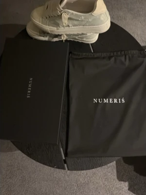 Vita sneakers från Numeris - Stilrena vita sneakers från Numeris med breda vita skosnören och låg profil. Skorna har en klassisk siluett och är tillverkade i slätt material med diskret branding på plösen. Perfekta för dig som gillar minimalistisk och clean stil. Köpta på deras hemsida för ungefär ett halv år sen, säljer pågrund av att jag inte använder dem!