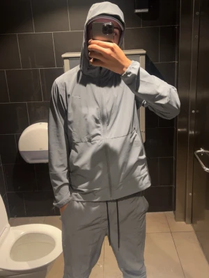Ljusgrå mjukisbyxor med dragsko - Säljer ett par ljusgrå mjukisbyxor med avslappnad passform och justerbar dragsko i midjan. Byxorna har raka ben och är tillverkade i ett mjukt, bekvämt material som passar perfekt för chill dagar. Matcha med hoodie för en clean look.