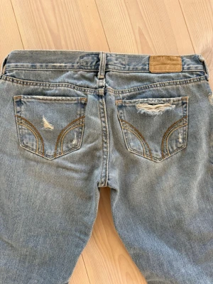 Hollister jeans  - Snygga lågmidjade bootcut jeans från Hollister med hål på knäna 💗 Köpta för 2000kr!! Pris kan diskuteras men kom med rimliga prisförslag 