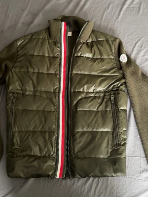 Moncler cardigan  - Snygg olivgrön pufferjacka från Moncler. Perfekt nu till hösten! Passar 170-175 cm