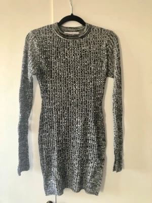 NLY Trend Stickad Tunika / Tröja m. Slitsar – Stl S - Melerad stickad tröja/tunika från NLY Trend i svart och vitt. Lång modell med cool Y2K/90-talskänsla! Har höga slitsar i båda sidorna nedtill samt stilrena slitsar vid ärmsluten. Storlek: S Mått: Ca 77 cm lång från axel, axelbredd ca 36 cm Material: 100% akryl (mjuk och stretchig) Skick: Mycket fint begagnat skick!