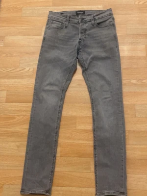 Gråa skinny jeans med fem fickor - Snygga gråa skinny jeans med klassisk femficksdesign och smal passform. Jeansen har dragkedjegylf och bälteshällor, samt diskreta sömmar på bakfickorna. Perfekta för en trendig och avslappnad stil.