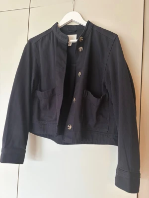 Mörkblå kort cardiganjacka - Snygg mörkblå cardiganjacka ä och stora knappar framtill , jeans material och passar väldigt bra till hösten! 