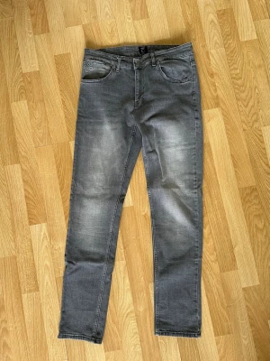 Gråa Hugo Boss Jeans - Säljer ett par oanvända grå jeans från BOSS med klassisk femficksmodell och diskret tvättade detaljer. Jeansen har normal passform och är tillverkade i mjukt bomullsmaterial med en liten stretch för extra komfort.