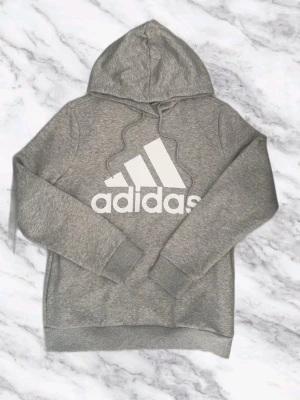 Grå hoodie från Adidas - Säljer en hoodie från Adidas. Bra kvalitet. Inga defekter vad jag sett. 7-8/10 