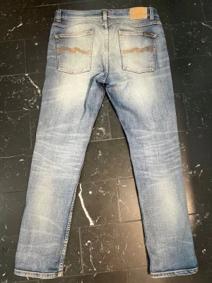 Nudie Lean Dean - Märke & Modell: Nudie, Lean Dean Storlek: W33 L30 (Passar S/M) Passform: Slim (Men åt rakare hållet) Skick: 9/10 Om plagget: Riktigt feta och unika Lean Deans som är authentic stiched, dvs massvis av design som inte är riktigt slitage utan fabrikat av proffs. Fräsch ljusblå färg med orange stitching och bakfickor. Info: 100% äkta | Postas inom 24h | Skriv vid frågor eller önskemål om fler bilder! 👖