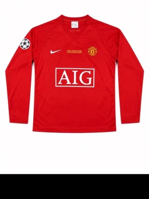 Manchester United fotbollströja - Röd långärmad Manchester United-tröja från Nike med AIG som sponsor och Champions League-märke på ärmen. Tryck med nummer 7 och namn på ryggen. Perfekt för fotbollsfans som vill sticka ut på planen eller läktaren.
