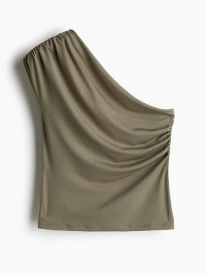Khakigrön one shoulder topp - En Khakigrön one shoulder topp från H&M. En figurnära topp i stadig trikå med bar axel och asymmetrisk ringning. Toppen har rynk på ärmen och på motsatt sida i midjan för en lätt draperad effekt. Storlek XL men skulle nog mer passa en M/L. Använd enstaka gånger, inga tecken på användning 💚