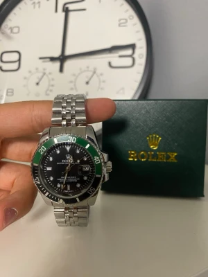 Rolle klocka med grön och svart detalj - Helt ny Rolle, skriv om ni undrar något..                         Liten box följer med (första bilden)