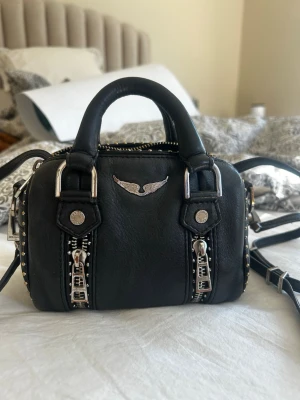 Svart handväska med nitar och kedjedetaljer - VÄLDIGT BRA PRIS‼️‼️nypris 4000kr. Fin Sunny bag från Zadig & Voltaire som använts flitigt💕 säljer den lilla modellen, påse medföljer 🥰se alla bilder