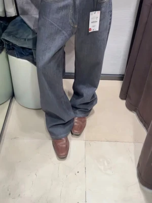 Mörkblå bootcut jeans med raka ben - Säljer ett par mörkblå jeans med loose fit och raka ben. Jeansen har klassiska fem fickor, kontrastsömmar och hög midja. Materialet är denim i bomull och passformen är avslappnad och trendig.
