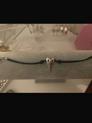 Svart armband med silverberlock  - Snyggt armband med svart band och ett silverfärgat berlock. Perfekt för dig som gillar unika detaljer och stilrena accessoarer. Passar perfekt till konsert/festival!!