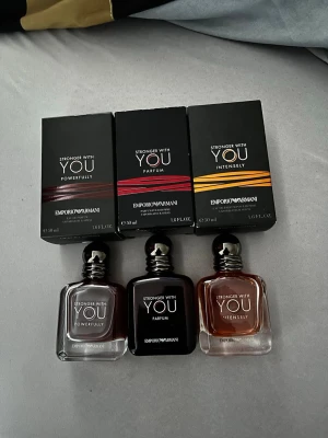 Stronger With You Set - Set med tre parfymer från Emporio Armani: Stronger With You Powerfully, Parfum och Intensely. Flaskorna är fyrkantiga med rundade kanter och har svarta och silverfärgade detaljer. Varje doft har sin egen färgton på vätskan och matchande förpackning.