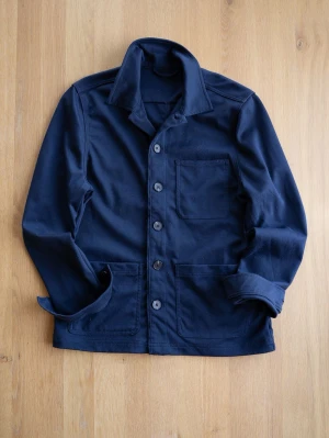 Navy Chore Jacket, size S - Stilren mörkblå stretchig overshirt med klassisk krage och knäppning framtill. Tre stora utanpåliggande fickor, en på bröstet och två nedtill. Perfekt lager-på-lager-plagg för en avslappnad look.