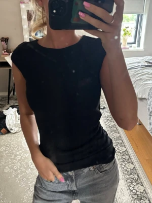 Svart topp - Jätte fin svart topp med detalj på höger sida knappt använd bra skick! Inga hål.