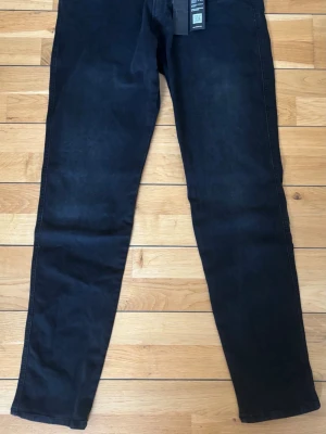 Mörkblå slim fit jeans från replay - Snygga mörkblå slim fit jeans med klassisk femficksdesign och raka ben. Jeansen har en stilren look och är tillverkade i ett stretchigt denimtyg som ger skön passform. Perfekta för dig som gillar en enkel och modern stil.