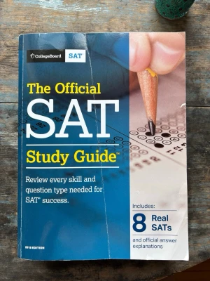 The Official SAT Study Guide 2018 - En tjock kursbok på engelska för SAT-förberedelser från CollegeBoard. Omslaget är blått och gult med en bild på en hand som fyller i ett svarshäfte. Innehåller 8 riktiga SAT-prov och svarsförklaringar. Perfekt för dig som vill plugga inför SAT-testet. Omslaget är lite slitet/vikt men oanvända test 