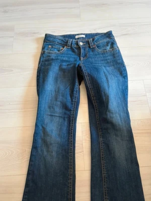 Blå bootcut jeans från ginatricot - Snygga blå bootcut jeans från Gina Tricot i klassisk denim med kontrastsömmar. Modellen har normal midja, fem fickor och utsvängda ben. Perfekta till en avslappnad och trendig stil.