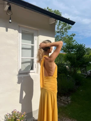 Gul halterneckklänning - Säljer en så fin klänning,  fint i skick! Använd 2 gånger. Jag är 177cm lång och klänningen går ner till marken.