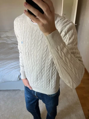 Beige kabelstickad tröja från Morris  - Säljer en snygg sjukt snyggt stickad tröja från Morris. Tröjan är i storleken L och i ett mycket fint skick utan defekter! 😁✌🏼        ——————————————————————————                                                                          📐| Storlek: Large                                                             👖| Märke: Morris Stockholm                                      🔎| Skick: Mycket Fint!                                                     ✍🏻| Skriv om du har några frågor