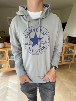 Converse hoodie tunn herr grå - Ljusgrå hoodie från Converse.Stort blått All Star-tryck fram.Mjuk, bekväm och perfekt till vardags.I fint begagnat skick.#converse#hoodie#gråhoodie#chucktaylor#streetwear#casual#herrkläder#allstar. Små defekter här o där. Allt finns inte med på bild så skriv om du vill ha fler bilder. Defekterna är knappt synliga i inget man tänker på.
