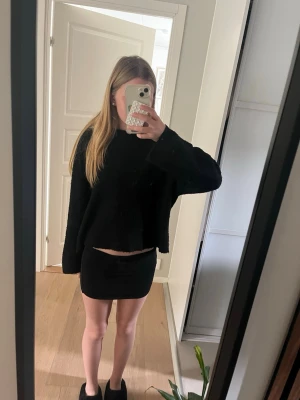 Svart tight minikjol - Säljer en svart tight minikjol med enkel och stilren design. Kjolen har en kort passform och är perfekt för dig som gillar en minimalistisk look. Materialet känns mjukt och stretchigt vilket gör den bekväm att bära. den kan också användas som en tube topp