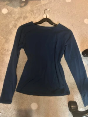 Mörkblå långärmad topp - Jättefin träningströja från Intermezzo passar perfekt till tex konståkning eller bara att ha som en varm tröja under vintern. Tröjan är lite fodrad på insidan. Den är lite nopprig men annars inga tecken på slitage. Storlek M men passar mer som S
