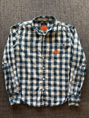 Superdry flanellskjorta ~ vintage  - Sjukt eftertraktad Superdry flanellskjorta ~ vintage modell | st L | färg marinblå/vit | saknar en knapp | klassisk passform | sällsynt 2000’s modell | OBS kan gå ner lite i pris vid snabb affär! 🏄